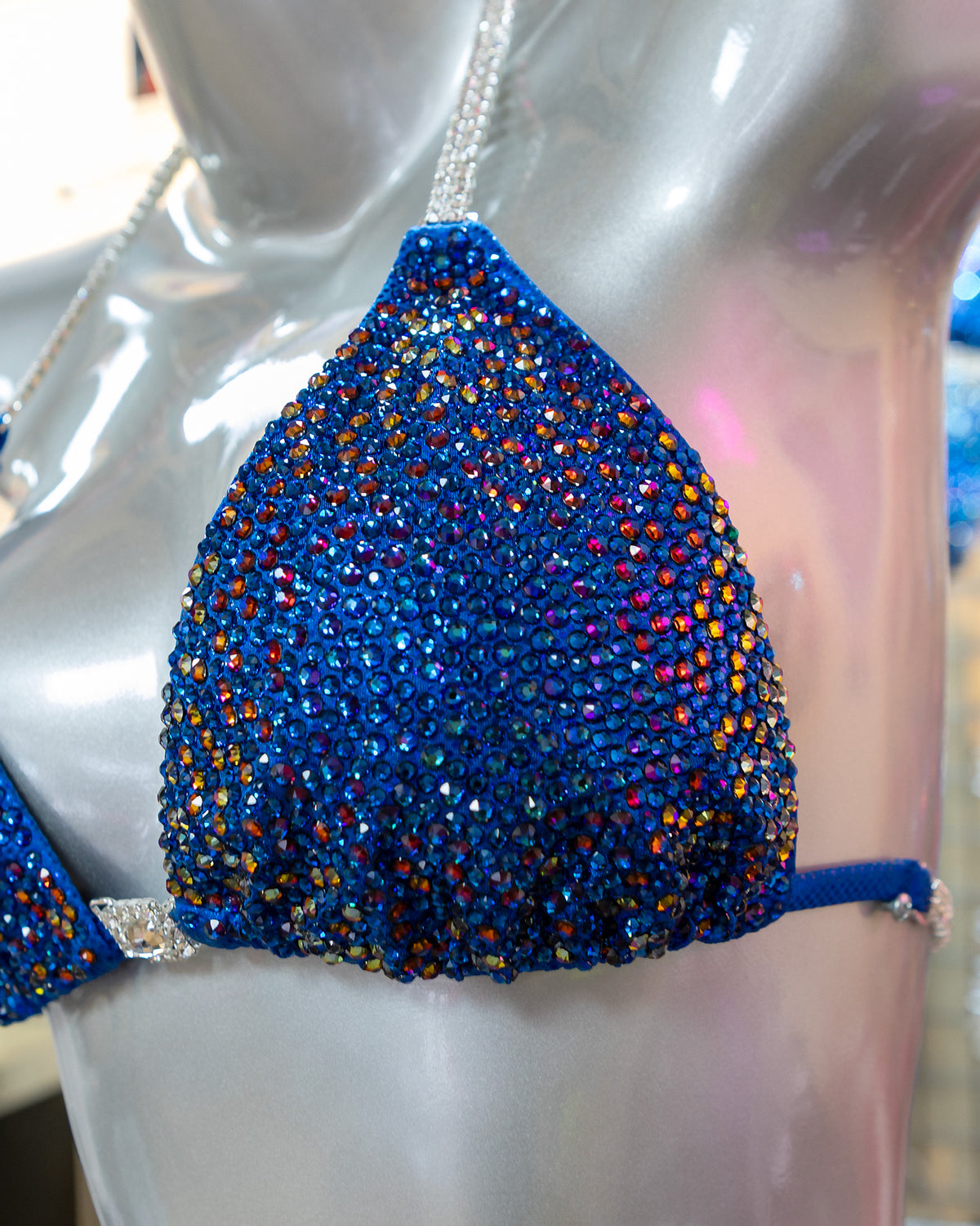 Close-up of genuine Swarovski® crystals on blue in-stock competition bikini fabric, Clearwater-made NPC/IFBB suit
